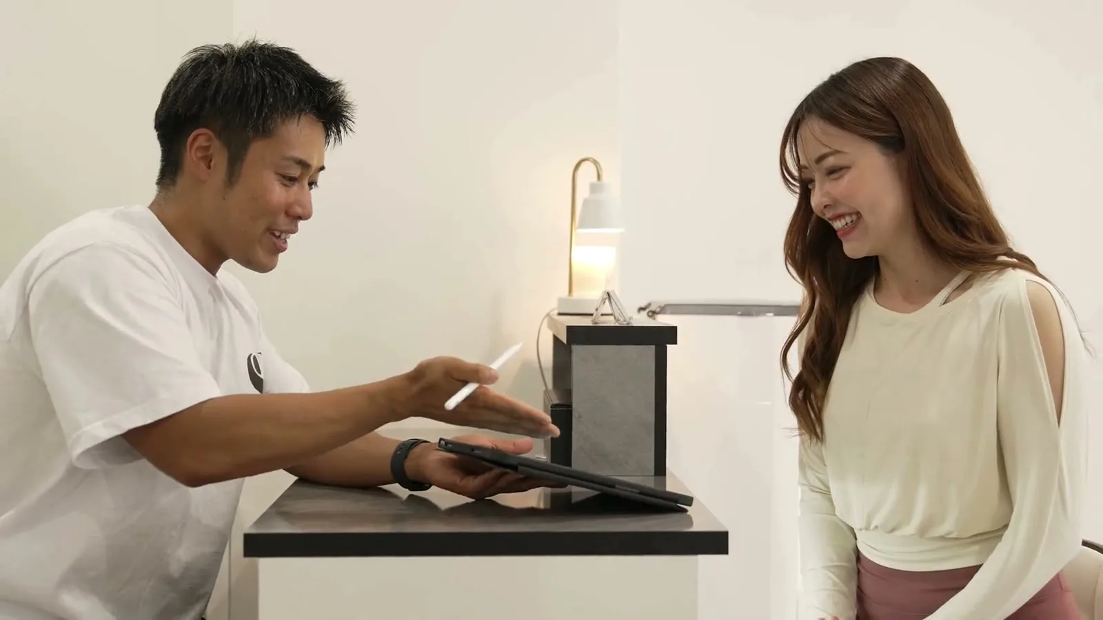 タブレットを見ながら身体の状態を確認するお客様とSTLiNEトレーナー
